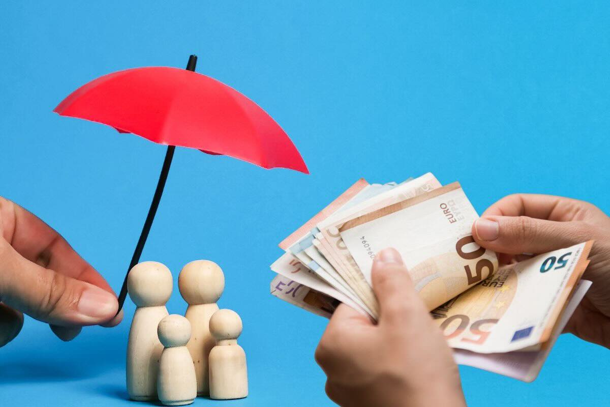 Omini in legno sotto ombrellino rosso, banconote euro